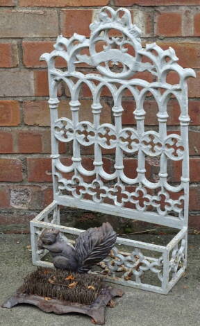 A Victorian style wall mounted shelf or compartment, decorated with gothic, etc., 68cm x 40cm, and a cast iron squirrel mounted boot scrape or cleaner.