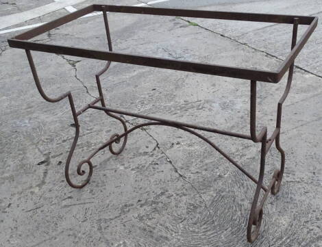 A wrought iron table base, on shaped supports, 73cm high, the top 50cm x 99cm.