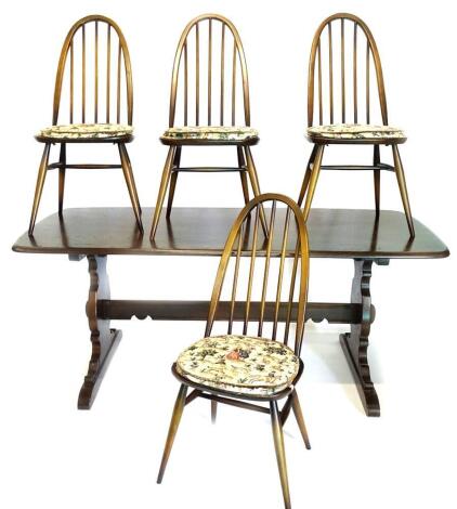 An Ercol oak and elm rectangular kitchen table, the top with rounded corners and a moulded edge, on end supports, 73cm high, top 77cm x 176cm, and four matching kitchen chairs. The upholstery in this lot does not comply with the 1988 (Fire & Fire Furnishi