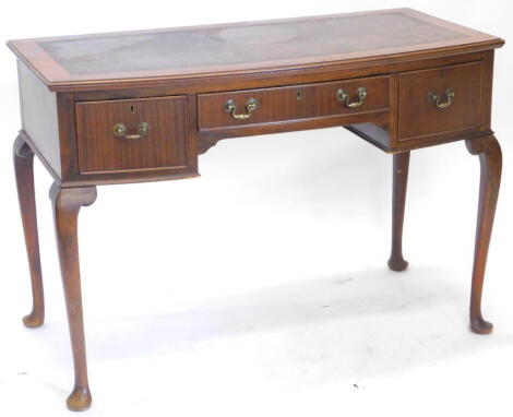 A mid-20thC mahogany bow fronted writing table, the top with a brown leather inset, above three frieze drawers on cabriole legs with pad feet 105cm wide.