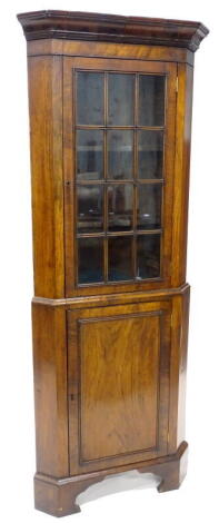 A walnut standing corner cabinet in mid-18thC style, the top of the cabinet with a glazed door and the base with a panel door on bracket feet 68 wide.