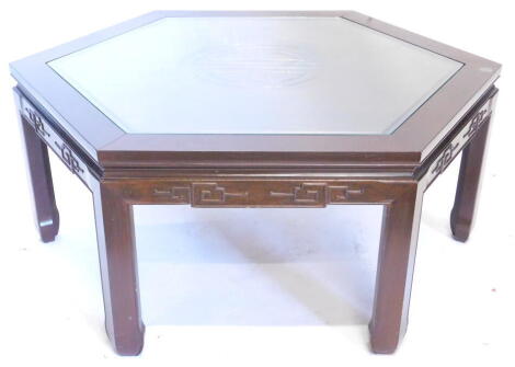 An oriental hardwood octagonal coffee table, with a glass insert, carved frieze on shaped legs, 94cm wide.