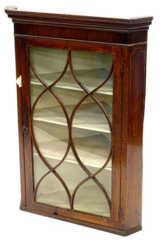 An early 19thC mahogany and boxwood strung glazed hanging corner cabinet, the top with a moulded cornice, 107cm high, 75cm wide. Provenance: The Estate of Miss Rachel Monson.