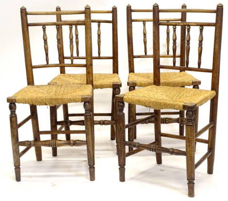 A set of four late 18th/early 19thC ash spindle back dining chairs, each with a rush seat, on turned tapering legs. Provenance: The Estate of Miss Rachel Monson.