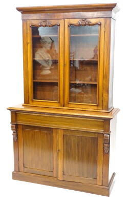 A Victorian mahogany bookcase, the top with a moulded cornice above two glazed doors enclosing adjustable shelves, the base with a moulded edge above a frieze drawer and two panelled doors, with plain sides and plinth base, top and base possibly associate