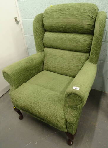 An armchair, in green fabric. The upholstery in this lot does not comply with the 1988 (Fire & Fire Furnishing) Regulations, unless sold to a known exporter or upholsterer it will be cut from the frame before leaving the premises.