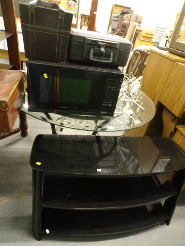 A glass three tier TV stand, a glass topped table with metal base, a Kenwood 900w microwave, metal wine rack, a Sentry safe, various CD's (a quantity).