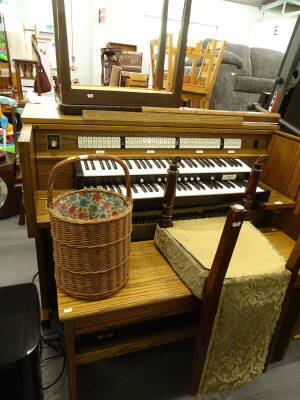 An Allen Protege electric organ, in an oak case, a long stool or bench, wicker basket, etc. The upholstery in this lot does not comply with the 1988 (Fire & Fire Furnishing) Regulations, unless sold to a known exporter or upholsterer it will be cut from t