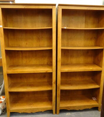 A pair of open bookcases, each with carved decoration.