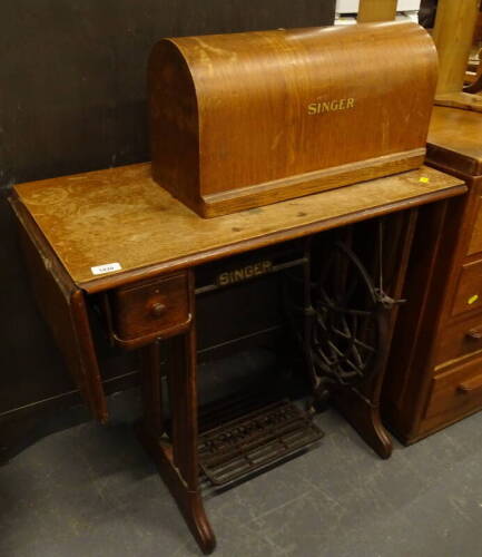 A Singer treadle sewing machine, in oak case.