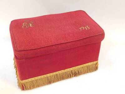 A 1953 Coronation stool, for Queen Elizabeth II, of rectangular section with red fabric, stitched with the Royal cypher and coronet, and dated 1953, with tassled fringe, 23cm high, 41cm wide, 26cm deep.