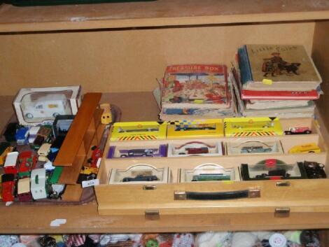 A collection of various die-cast model vehicles and an assortment of children's books