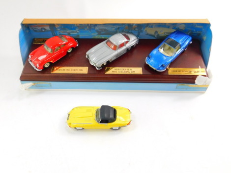 A Dinky die cast classics sports cars series one three car set, comprising a Porsche 356A coupe 1958, Mercedes Benz 300SL gull wing 1935, and a Ferrari D2046GTS93, on a wooden stand, DY-902, together with a Dinky 1967 Jaguar E-Type Mark 1 ½, DY-1B, both b