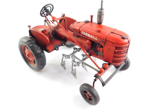 A tin plate red Farmall tractor, 34cm wide.