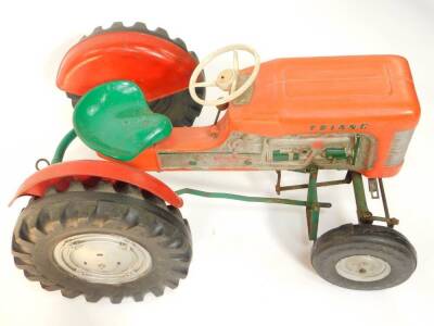A Tri-ang ride on pedal tractor, red and green, 97cm wide.