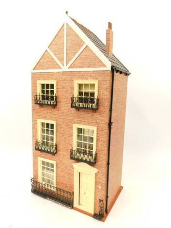 A three storey Victorian style doll's house, with fitted interior and dolls, 42cm wide, 30cm deep, 87cm high.