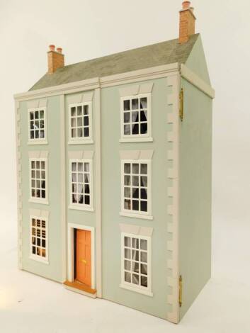 A Georgian style doll's house, the front opening to reveal three floors with six rooms, furnished, 82cm high, 60cm wide, 31cm deep.