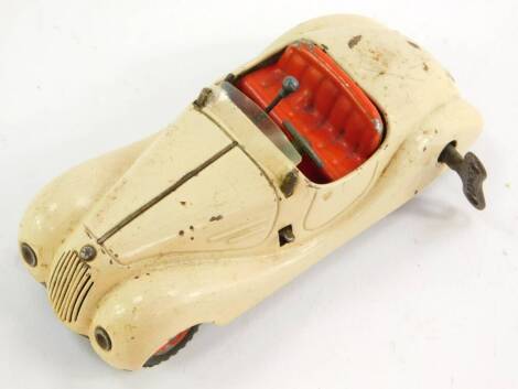 A Schuco Examico 4001 tin plate clockwork motor car, cream with red interior, with key and box.