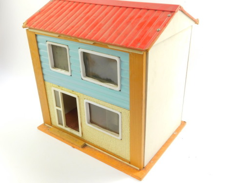 A mid 20thC wooden and plastic doll's house, with two floors, furniture and accessories.