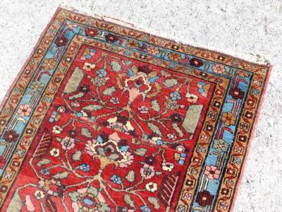 A Hammadan carpet runner, with stylised floral central field on red ground, enclosed by triple borders, with a turquoise central band, 320cm x 92cm. - 4