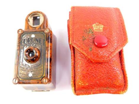 A Coronet midget camera, in a brown marbled Bakelite casing, with outer red leather wallet, 6cm high.