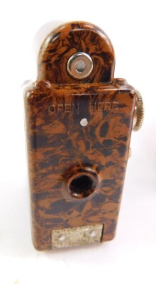 A Coronet midget camera, in a brown marbled Bakelite casing, with outer red leather wallet, 6cm high. - 2