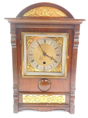 A French early 20thC oak cased mantel clock, square brass dial with foliate spandrels, silver chapter ring bearing Roman numerals, thirty hour movement, No 7024, the case of domed form with gilt floral and foliate embellishments, raised on bracket feet, w - 2