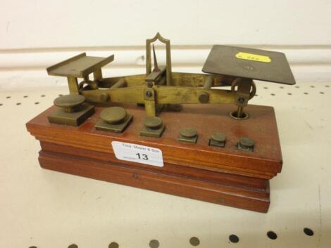 A set of mahogany and brass postal scales with six weights<br