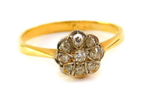 A diamond flower head ring, set with nine diamonds in platinum and yellow metal, stamped 18ct, approximately 0.3cts, size U, 3.8g all in.