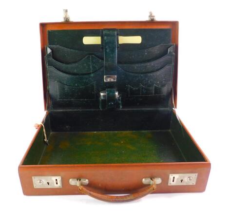 A tooled leather travelling writing or attache case, with fitted interior.