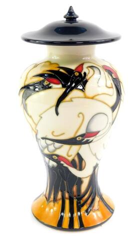 A Moorcroft pottery vase and cover, decorated in The Cranes of Cashmere pattern, of baluster form by E Bosson, limited edition 8/50, circa 2009, painted and impressed marks, 22.5cm high.