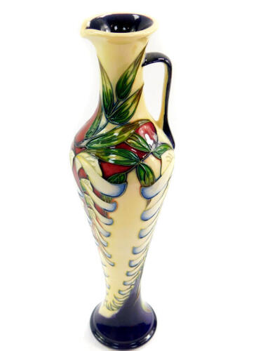 A Moorcroft pottery jug, decorated in the Wisteria pattern by Phillip Gibson, limited edition 54/150, 2005, of elongated balaster form, painted and impressed marks, 32cm high.