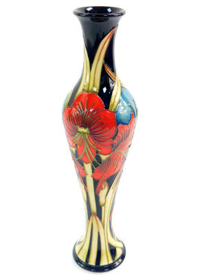 A Moorcroft pottery vase, decorated with stylised red flowers, designed by Kerry Goodwin, limited edition 20/50, circa 2011, of elongated baluster form, painted and impressed marks, 32cm high.