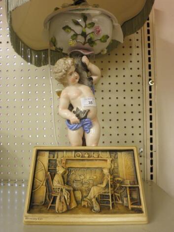 A Dresden type porcelain lamp base in the form of a putto and