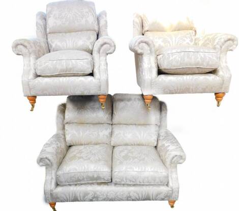 A Parker Knoll three piece suite, covered in foliate fawn fabric, comprising two seater sofa, 105cm wide, and a pair of armchairs.