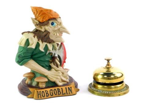 A Bell's Scotch whisky brass bar bell, LVNH Presidential Year 1986, together with a Hobgoblin resin figure, 22cm high. (2)