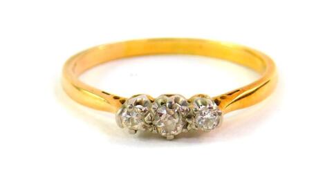 A diamond three stone ring, set in yellow metal, approx 1/8th carat, size P, 2.0g.