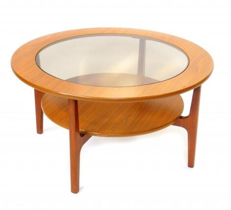 A Nathan Shades teak circular occasional table, with glass inset, based on square supports, raised on square legs with an x framed support, holding an under tier, 85cm diameter, 45cm high.