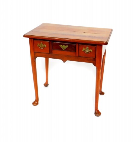 A George III mahogany side table, with three short frieze drawers, raised on turned legs, on pad feet, 73cm high, 74.5cm wide, 49cm deep.