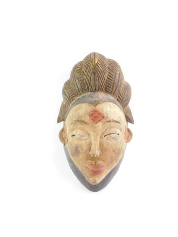 A carved and painted wooden Punu mask, 37cm high.