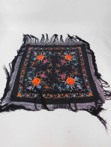 A Chinese vintage black silk shawl, probably early 20thC embroided with flowers, with a black fringe, 116cm square.