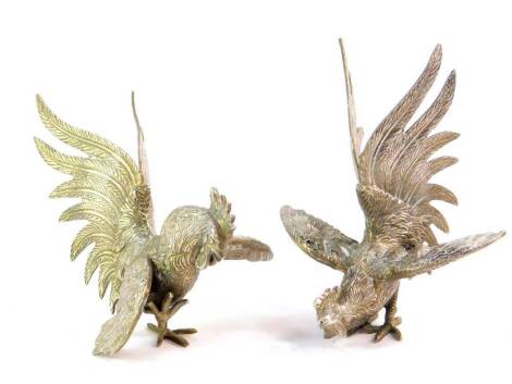 A pair of silver plated table ornaments, modelled as fighting cocks, 17cm high.