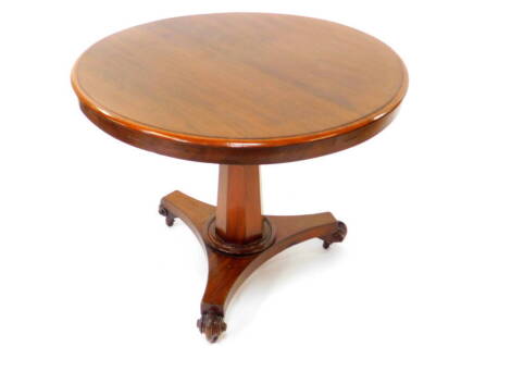 A late Regency mahogany circular tilt top breakfast table, raised on an outswept octagonal column, above a triform base, on castors, 70.5cm high, 87cm diameter.