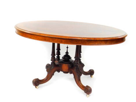 A Victorian walnut and inlaid oval tilt top breakfast table, raised on four turned columns, over leaf carved cabriole legs, on castors, 75cm high, 137cm wide, 102cm deep.