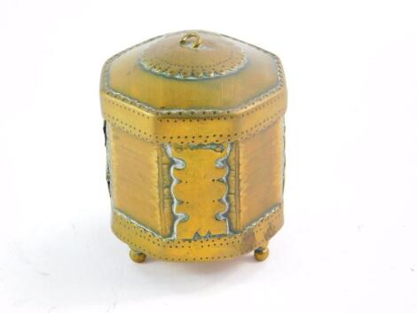 A Tibetan Buddhist brass and horn prayer wheel, of octagonal form, raised on three brass feet, 6.5cm diameter, 7cm high.