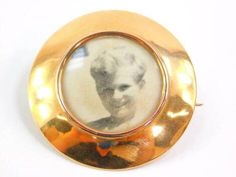 A circular photograph locket brooch, yellow metal stamped 15ct, 4cm diameter, 10.0g all in.