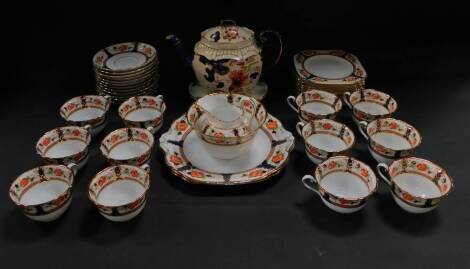 An early 20thC Tuscan porcelain tea service, decorated with flowers, comprising a pair of bread plates, cream jug and sugar bowl, twelve tea cups, saucers and tea plates, together with a Losol ware Tokio pattern teapot on stand.
