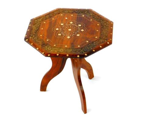 An Anglo Indian hardwood and ivory inlaid wine table, with a floral decorated and carved octagonal top, raised on three elephant heads supports, 35.5cm high, 35.5cm diameter.