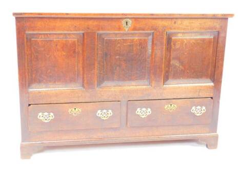 An early 18thC oak mule chest, the hinged lid above a triple panelled front over two frieze drawers raised on bracket feet, 122cm wide, 56.5cm deep, 86cm high.