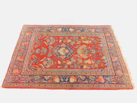 A Turkish red ground prayer rug, the central mihrab framing vases of flowers, birds, trees of life, animals, etc., within a floral border, 144cm x 109cm.